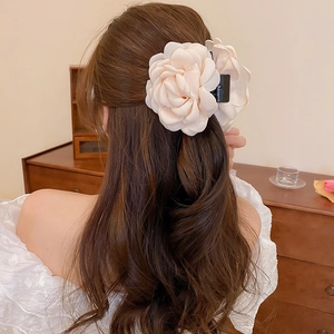 Elegant beige fabric flower hair claw clip worn on a half-up hairstyle back view