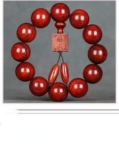 Macro shot of polished red sandalwood prayer beads with a Zhenpin carved pendant