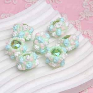 Macro shot of colorful oil-painted round beads on a white wave stand with lace