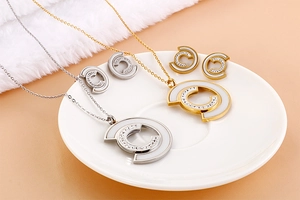 Detail shot of gold and silver C-shaped shell jewelry sets with crystals on a white saucer