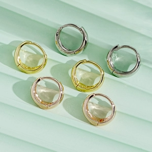 Detailed macro view of high-shine gold, silver, and rose gold chunky C-shaped hoop earrings