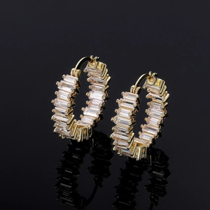 Macro shot of gold-plated hoop earrings with rectangular AAA zircon stones on black background