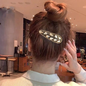 Elegant gold hair clip with waterdrop pearls and rhinestones shown on model hair