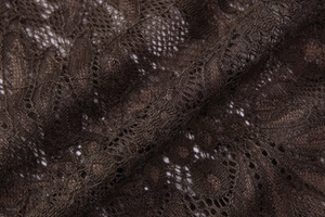 Détail de la dentelle marron foncé avec motifs floraux délicats et maille ajourée