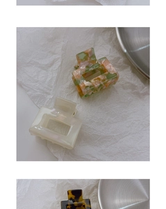 Macro shot of square acetate hair claw clips with floral marble and cream white finish