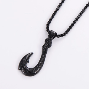 Macro shot of black box chain and Maui fish hook pendant with engraved textures