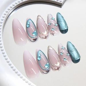 Pink and blue press-on nails with rhinestones and silver details on a pearl mirror base