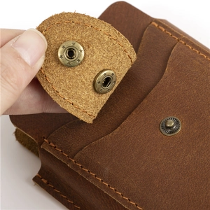 Macro detail of crazy horse leather waist bag with adjustable snap button closure