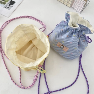 Close-up of drawstring gingham bucket bags in yellow and blue with woven handles