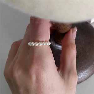 Minimalist white pearl chain ring on model hand showing an elegant soft aesthetic style