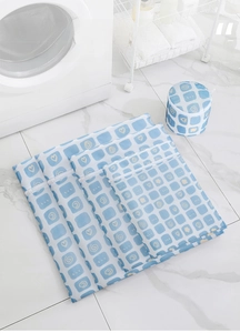 Five-piece printed mesh laundry bag set with blue patterns on a marble floor background