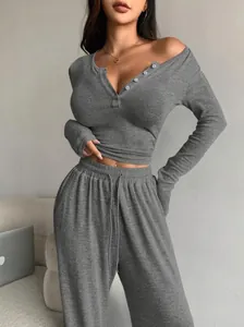 Detail of dark grey ribbed knit two-piece set featuring a Henley top and drawstring pants