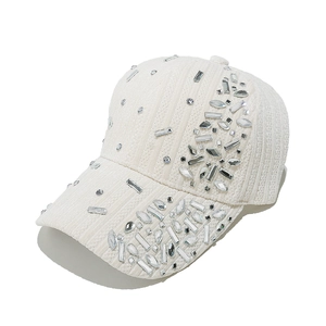 Detail of white velvet baseball cap featuring intricate silver rhinestone embellishments