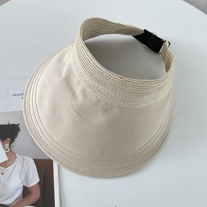 Detailed view of beige sun visor featuring woven straw trim and adjustable metal buckle
