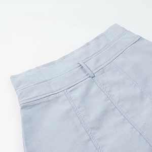 Détail du tissu en lin bleu clair avec doubles coutures et passants de ceinture sur le short