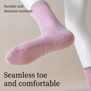 Pink and green cotton yoga socks with non-slip silicone grips and seamless toe design