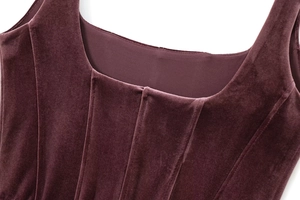 Close-up of burgundy velvet corset dress showing fabric texture and U-neckline detail