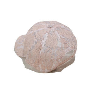 Dettaglio posteriore del berretto in pizzo rosa con fibbia regolabile sul retro