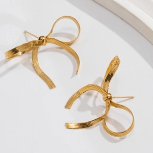 Detailed close-up of golden bow-shaped stud earrings with snake chain textured weaving