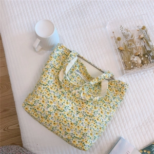 Close-up of floral cotton tote bag with zipper on a cozy white quilted background