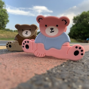 Détail de pinces à cheveux ourson mignon en acétate rose et marron brillant