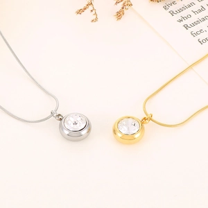 Detail of gold and silver necklaces featuring round cut crystal pendants and snake chains