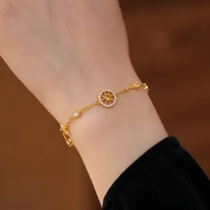 French style gold compass bracelet with zircon star pendants worn on a woman's wrist
