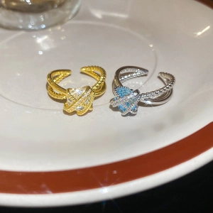 Macro detail of planet-shaped rings with twisted bands in gold and silver finishes
