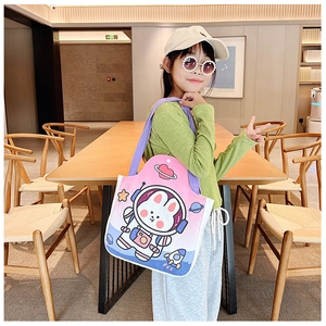 Detail of cute astronaut bunny print on pink canvas tote bag shown in lifestyle setting