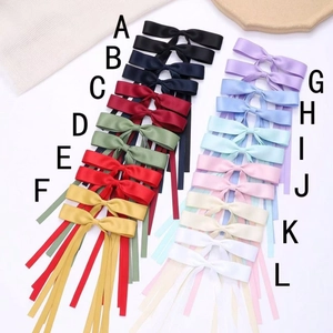 Set of 12 colorful ribbon bow hair clips with metal alligator grip on white background