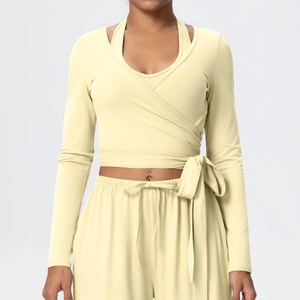 Detail of cream long-sleeve wrap yoga top with side bow tie and V-neckline finish