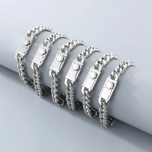 Detailed view of silver stainless steel Cuban link bracelets on a display stand