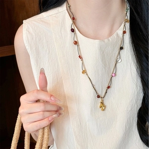Détail du collier pendentif cheval plaqué or 18K avec perles colorées sur un mannequin