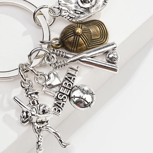 Detail of silver baseball glove, bat, and bronze cap charms on a metal keychain