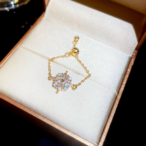 Detail eines verstellbaren Goldkettenrings mit Zirkonia-Blume auf einer Schmuckschatulle