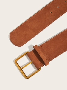 Detailed macro view of the brown suede leather texture and gold metal buckle on this belt