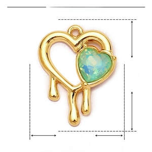 Macro detail of gold-plated stainless steel heart pendant with green resin stone