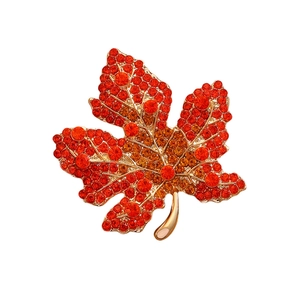 Elegant maple leaf brooch with red crystals and gold-tone metal setting for coats
