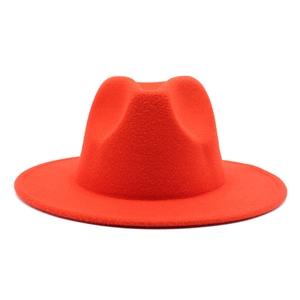 Detailed view of the red wide-brimmed wool felt fedora hat against a white background