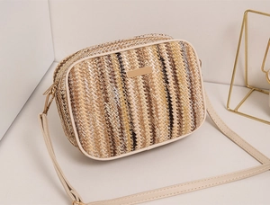 Close-up of woven straw texture and cream leather strap on the rainbow camera bag