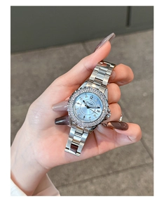 Detail showing woman's wrist with silver rhinestones watch and light blue sunray dial