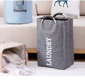 Detail of grey fabric laundry basket with aluminum handles and LAUNDRY text