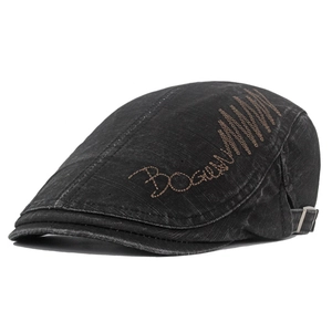 Detail view of washed cotton beret featuring side embroidery and adjustable metal buckle