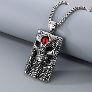 Macro shot of gothic skull pendant with a red stone eye and vintage steel chain