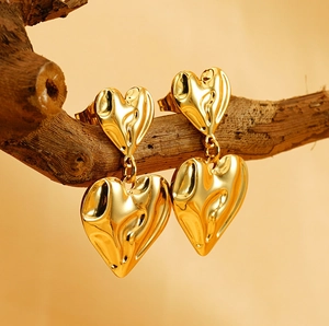 Vue détaillée de boucles d'oreilles cœur dorées avec surfaces métalliques texturées