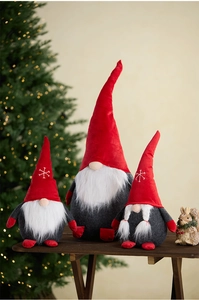 Macro detail of red Christmas gnomes with snowflake embroidery and white plush beards
