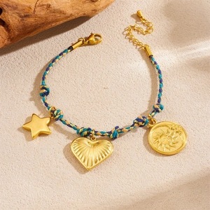 Bohemian braided rope bracelet with gold star heart and sun pendants on beige surface