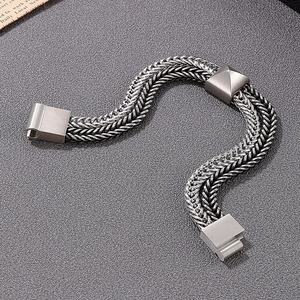 Macro shot of silver-gray woven stainless steel chain with matte metal buckle