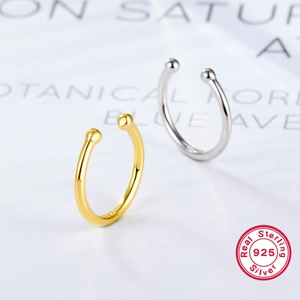 Macro detail of S925 sterling silver twist ear cuffs in gold and silver mirror finish