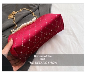 Detail showing the bottom structure and fine stitching of the red velvet shell bag